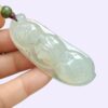 a hand holding a jade pendant - Bean with Bat