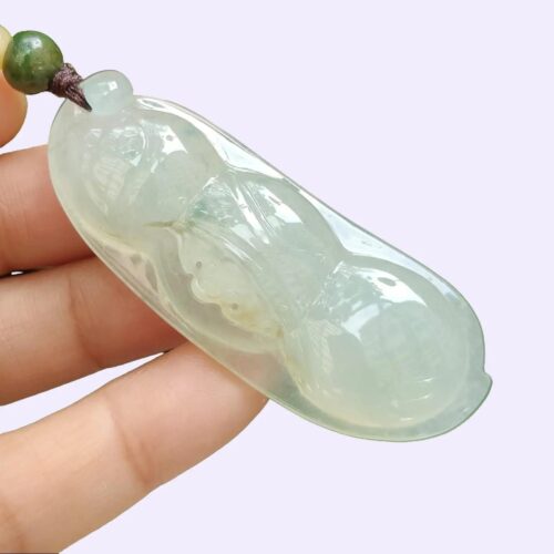 a hand holding a jade pendant - Bean with Bat