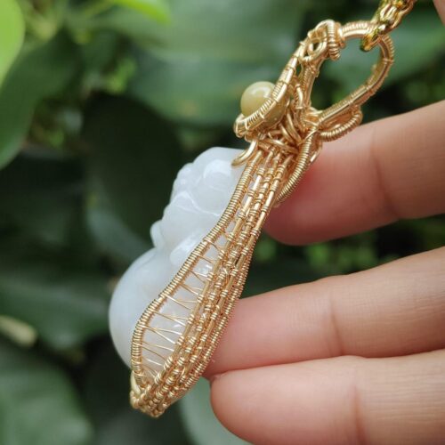 a hand holding a gold necklace - Milo Buddha