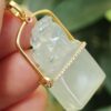 a hand holding a jade pendant - Diamonds setting 18k gold Pixiu