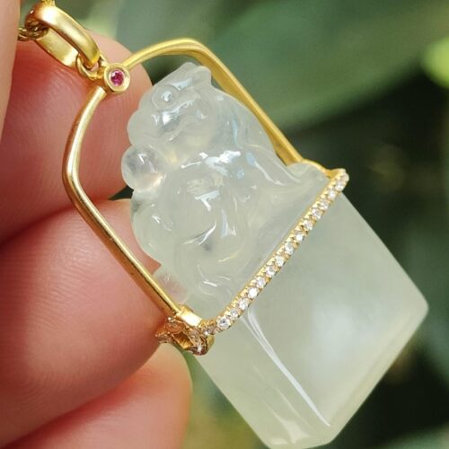a hand holding a jade pendant - Diamonds setting 18k gold Pixiu