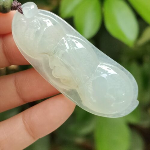 a hand holding a jade pendant - Bean with Bat