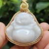 a hand holding a white jade pendant - Milo Buddha