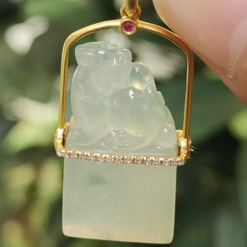 a hand holding a jade pendant - Diamonds setting 18k gold Pixiu