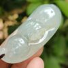 a hand holding a jade pendant - Bean with Bat