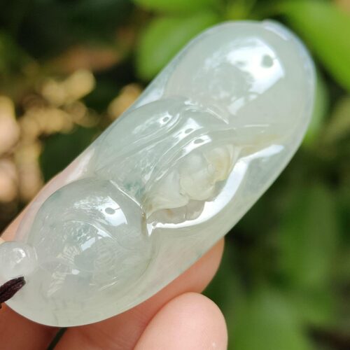 a hand holding a jade pendant - Bean with Bat
